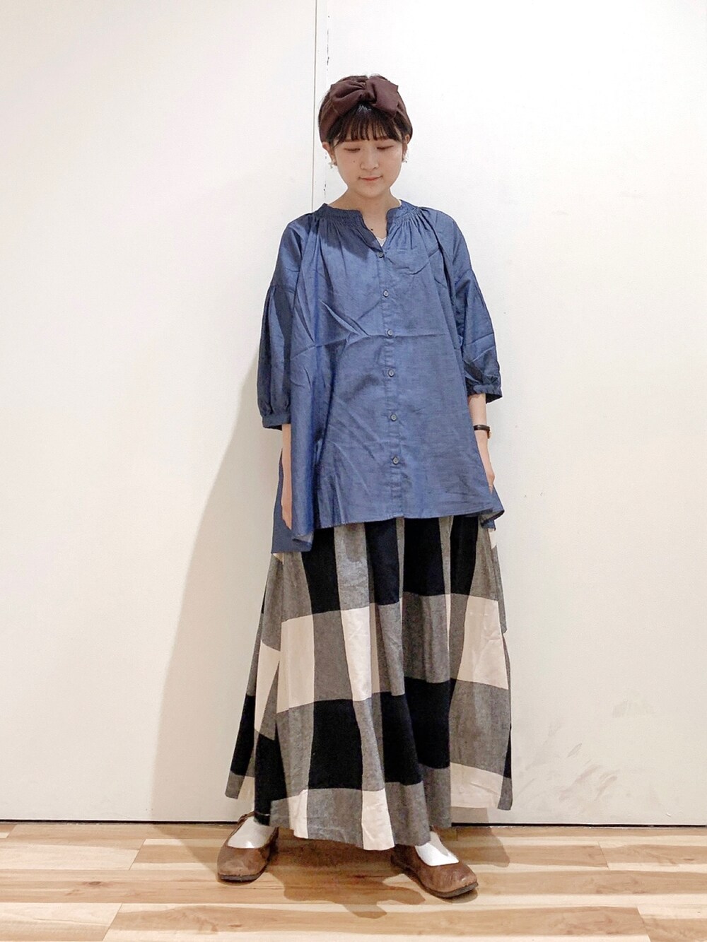 ブルー系のシャツ/ブラウス、ブラック系のスカート、ブラウン系のバレエシューズを着用したレディースの秋コーディネートの2枚目の写真