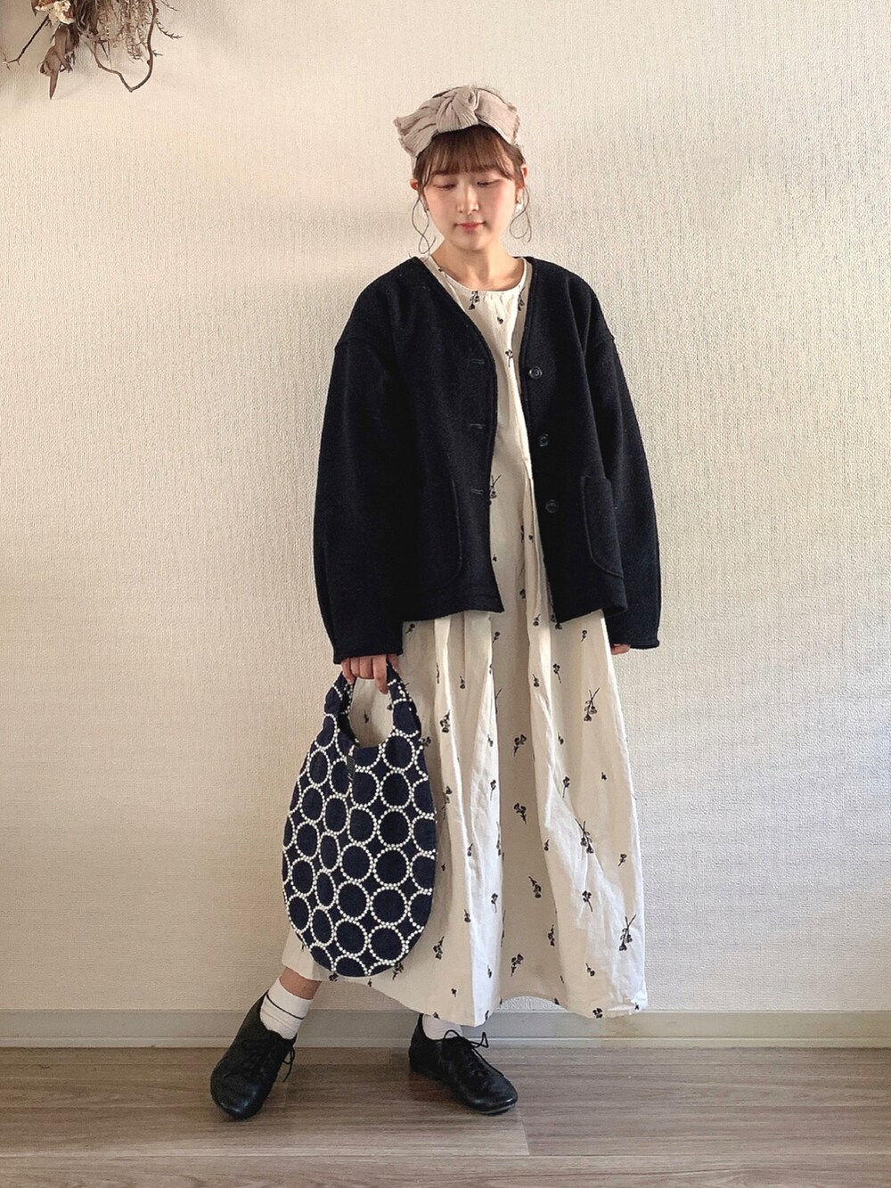 ブラック系のドレスシューズ、ブルー系のハンドバッグ、ホワイト系のワンピースを着用したレディースの冬コーディネートの2枚目の写真