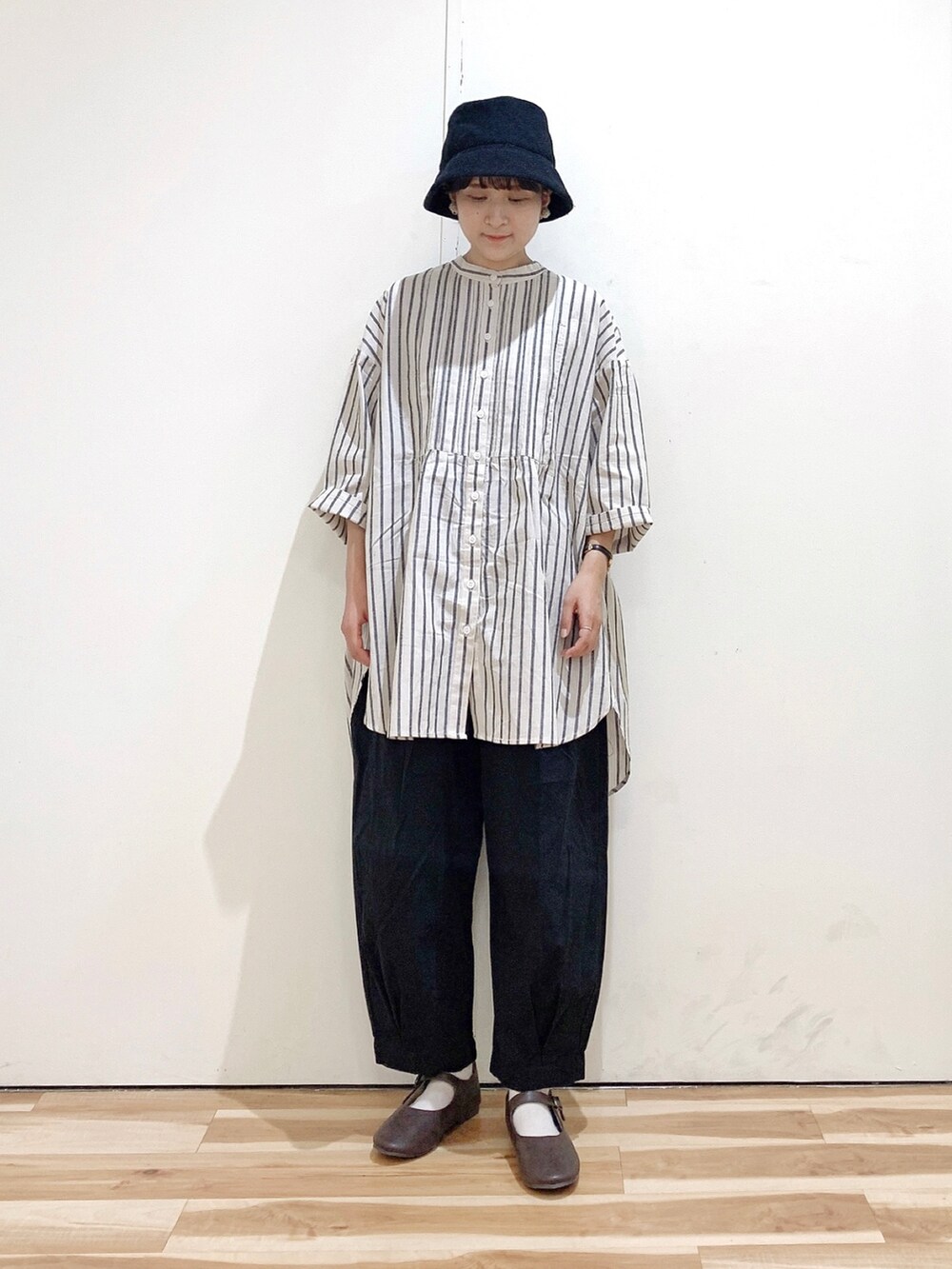 グレー系のシャツ/ブラウス、ブラック系のその他パンツ、ブラウン系のパンプスを着用したレディースの秋コーディネートの3枚目の写真