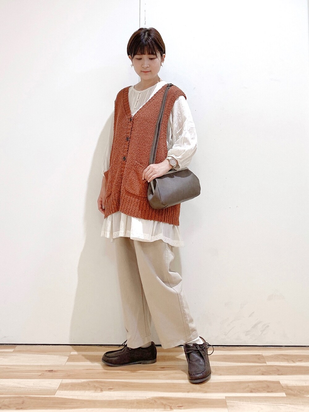 ブラウン系のハンドバッグ、ブラウン系のその他シューズ、ベージュ系のその他パンツを着用したレディースの秋コーディネートの2枚目の写真