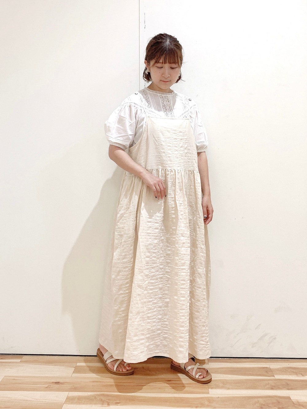 ホワイト系のサンダル、ベージュ系のワンピース、グレー系のベストを着用したレディースの夏コーディネートの5枚目の写真