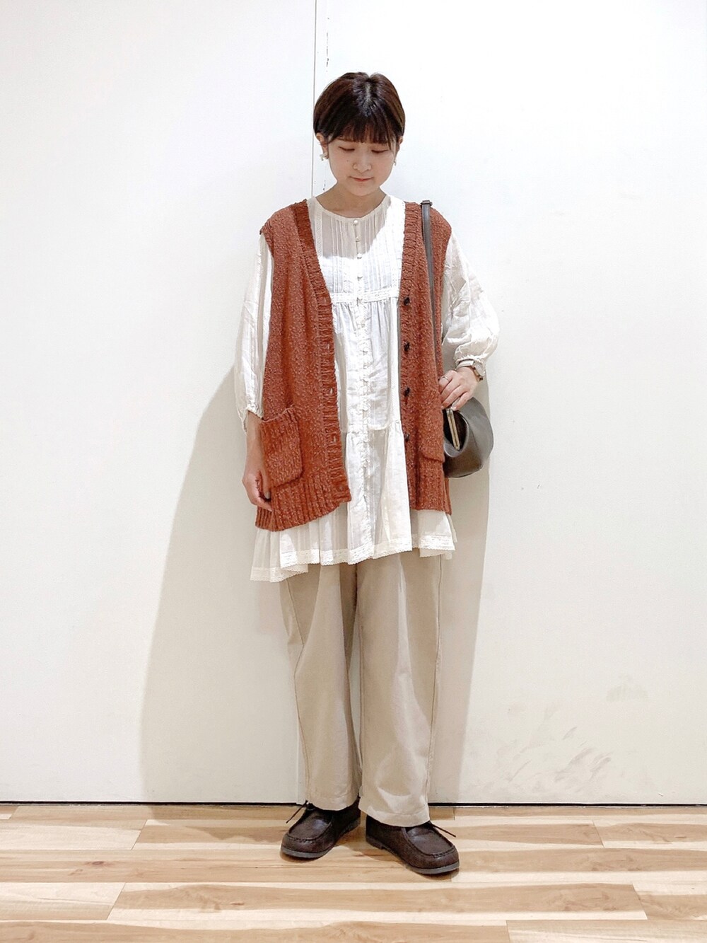 ブラウン系のハンドバッグ、ブラウン系のその他シューズ、ベージュ系のその他パンツを着用したレディースの秋コーディネートの4枚目の写真