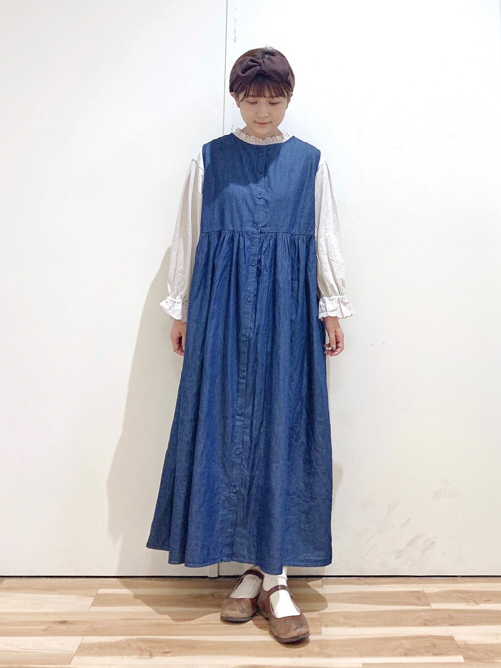 ブラウン系のバレエシューズ、ブルー系のワンピース、ホワイト系のTシャツ/カットソーを着用したレディースの秋コーディネートの3枚目の写真