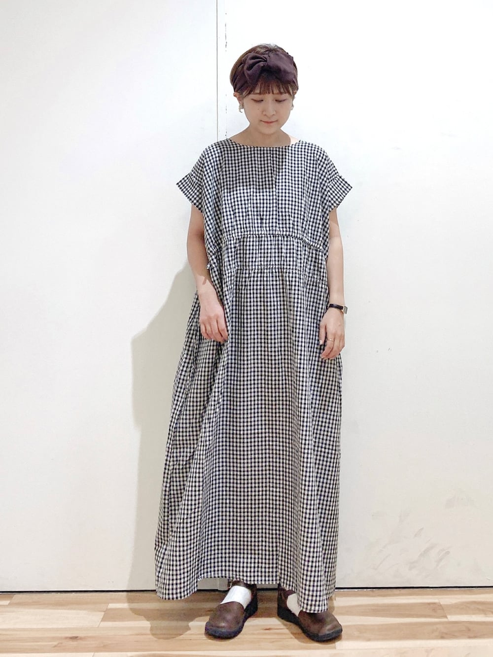 ベージュ系のワンピース、ブラウン系のシューズ、ブラウン系のヘアバンドを着用したレディースの夏コーディネートの2枚目の写真