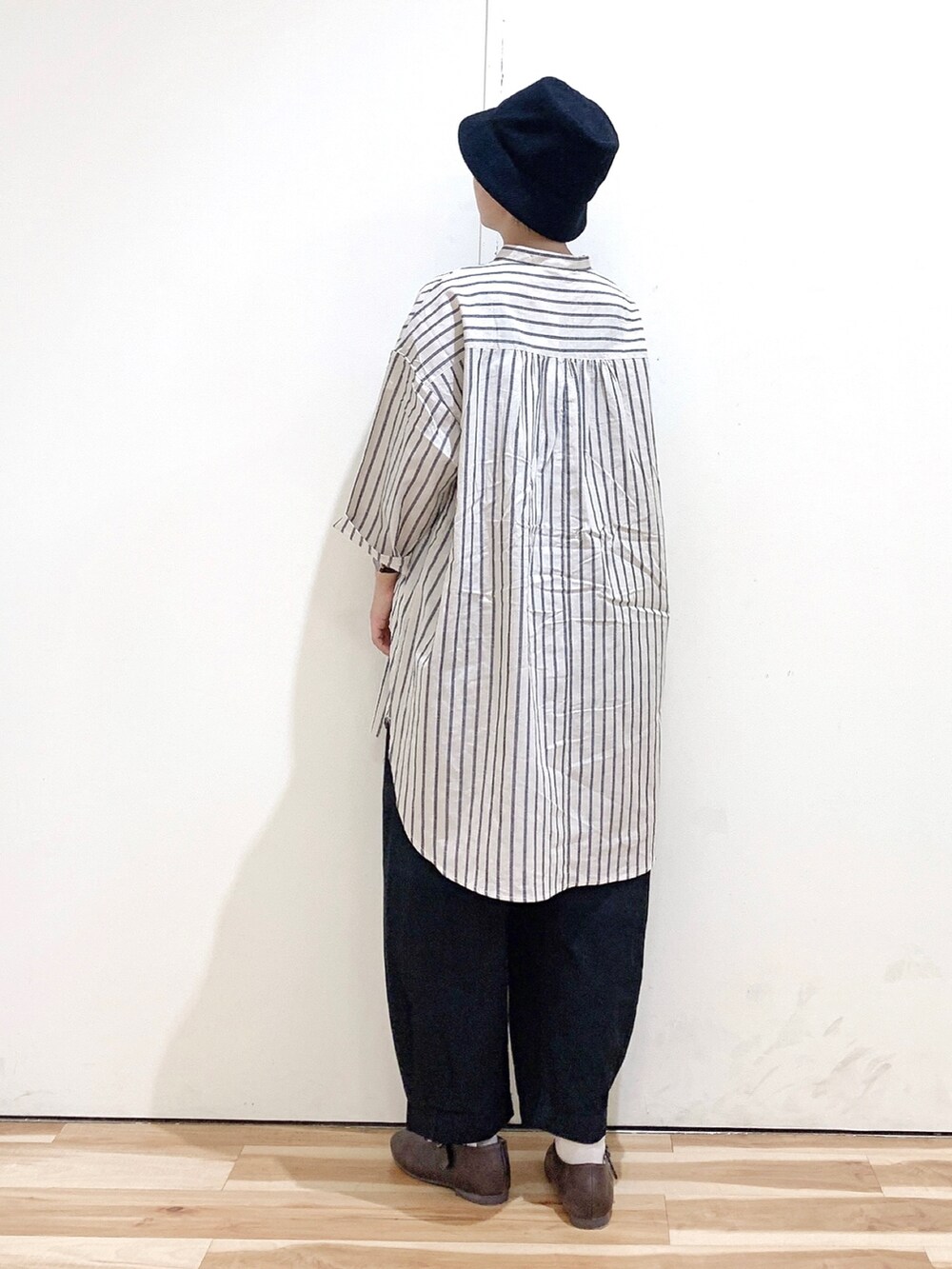 グレー系のシャツ/ブラウス、ブラック系のその他パンツ、ブラウン系のパンプスを着用したレディースの秋コーディネートの4枚目の写真