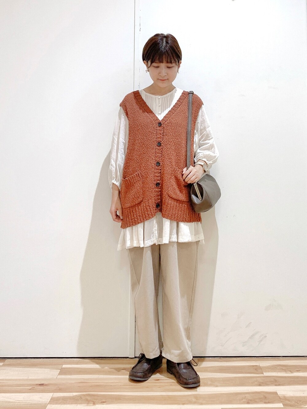 ブラウン系のハンドバッグ、ブラウン系のその他シューズ、ベージュ系のその他パンツを着用したレディースの秋コーディネートの3枚目の写真