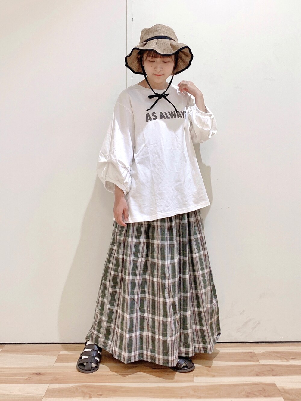 ブラウン系のサンダル、ホワイト系のTシャツ/カットソー、グリーン系のスカートを着用したレディースの春コーディネートの2枚目の写真