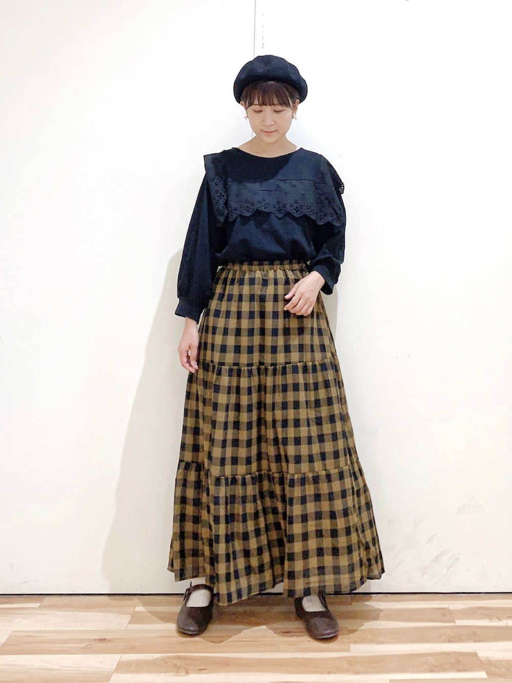 ブラック系のTシャツ/カットソー、ブラウン系のパンプス、イエロー系のスカートを着用したレディースの秋コーディネートの3枚目の写真