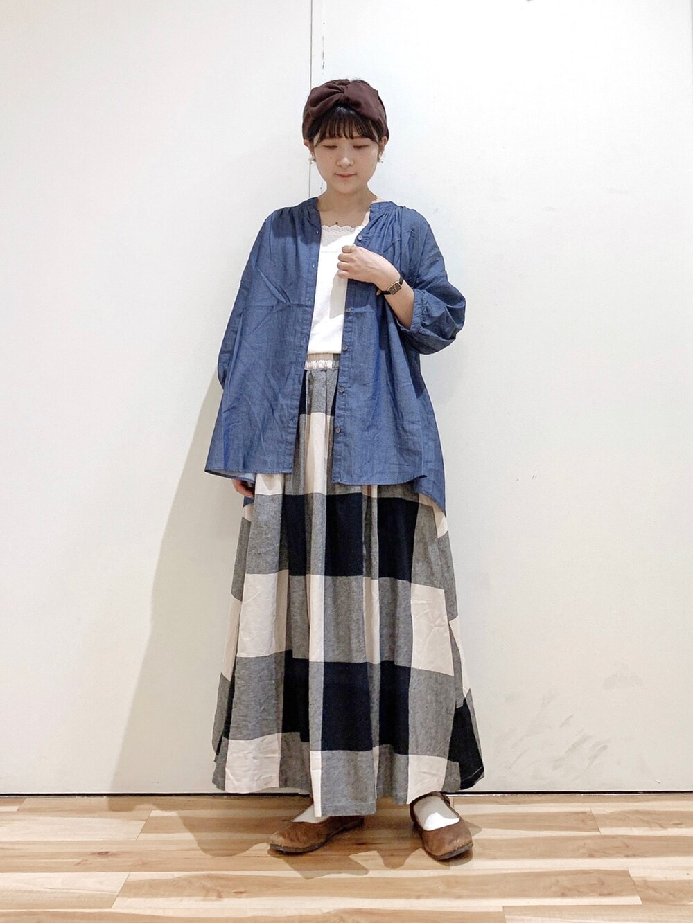 ブルー系のシャツ/ブラウス、ブラック系のスカート、ブラウン系のバレエシューズを着用したレディースの秋コーディネートの4枚目の写真