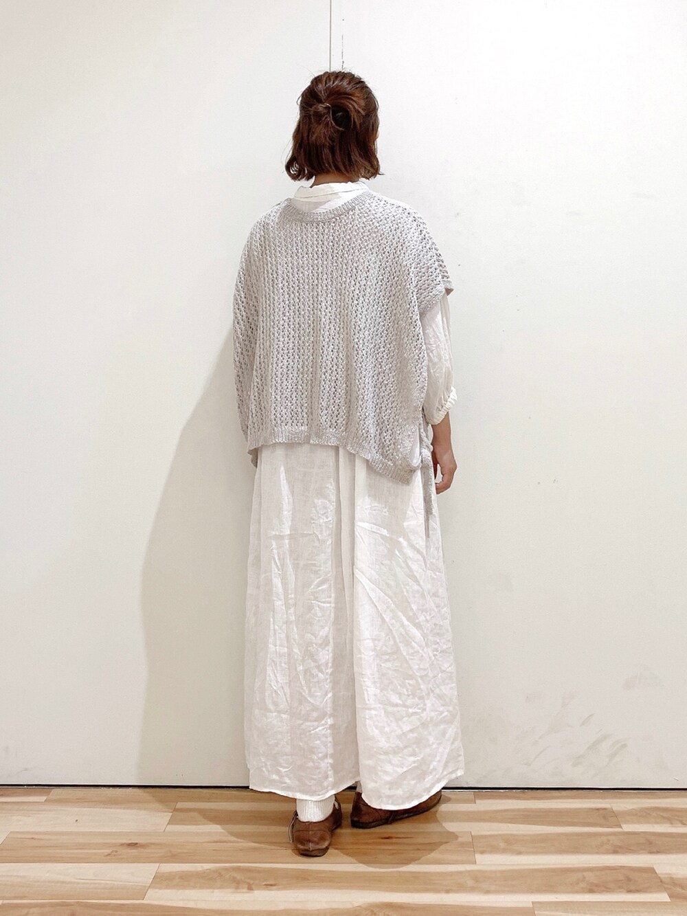 ブラウン系のバレエシューズ、ホワイト系のワンピース、ベージュ系のベストを着用したレディースの夏コーディネートの5枚目の写真