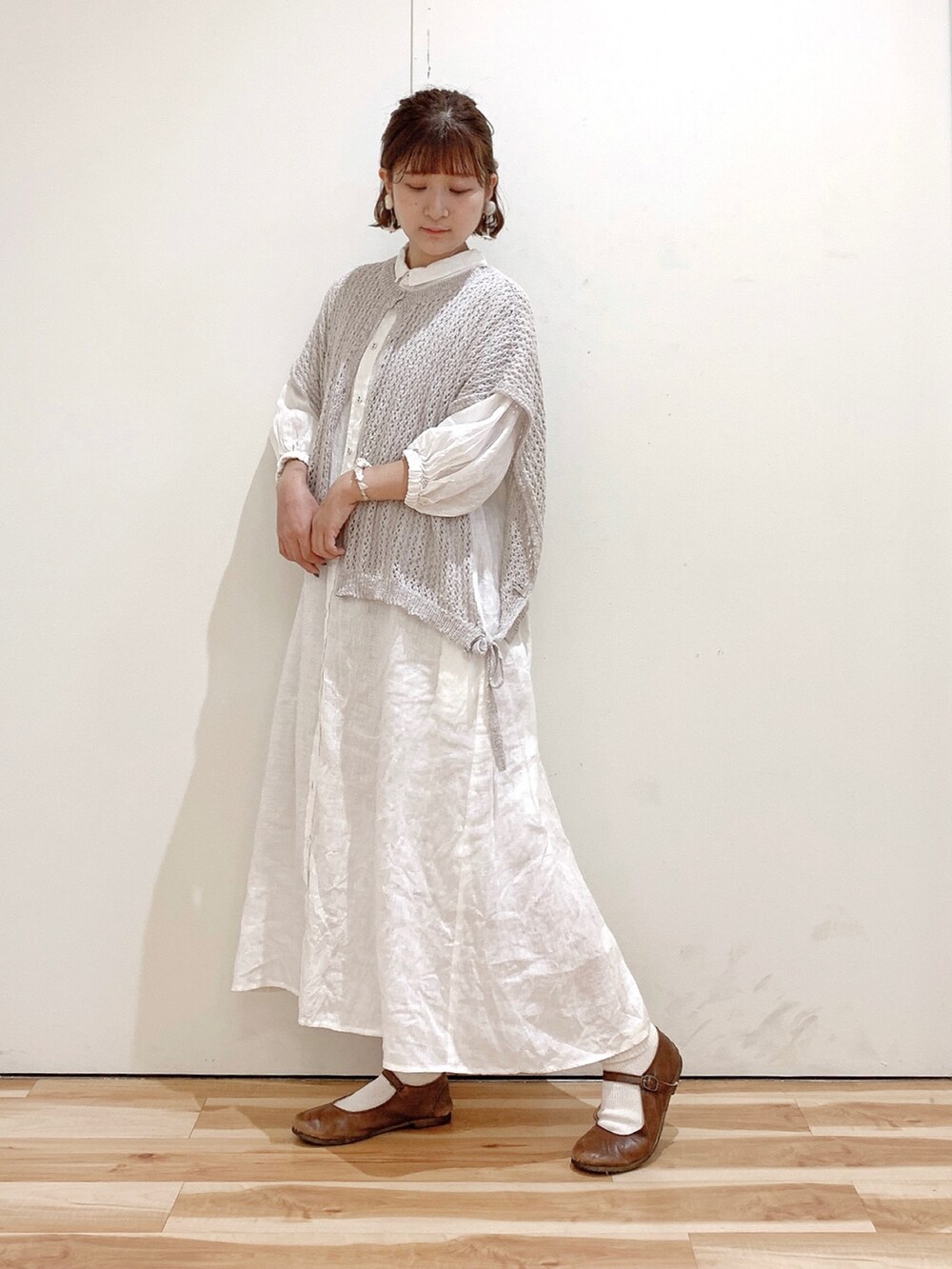 ブラウン系のバレエシューズ、ホワイト系のワンピース、ベージュ系のベストを着用したレディースの夏コーディネートの2枚目の写真