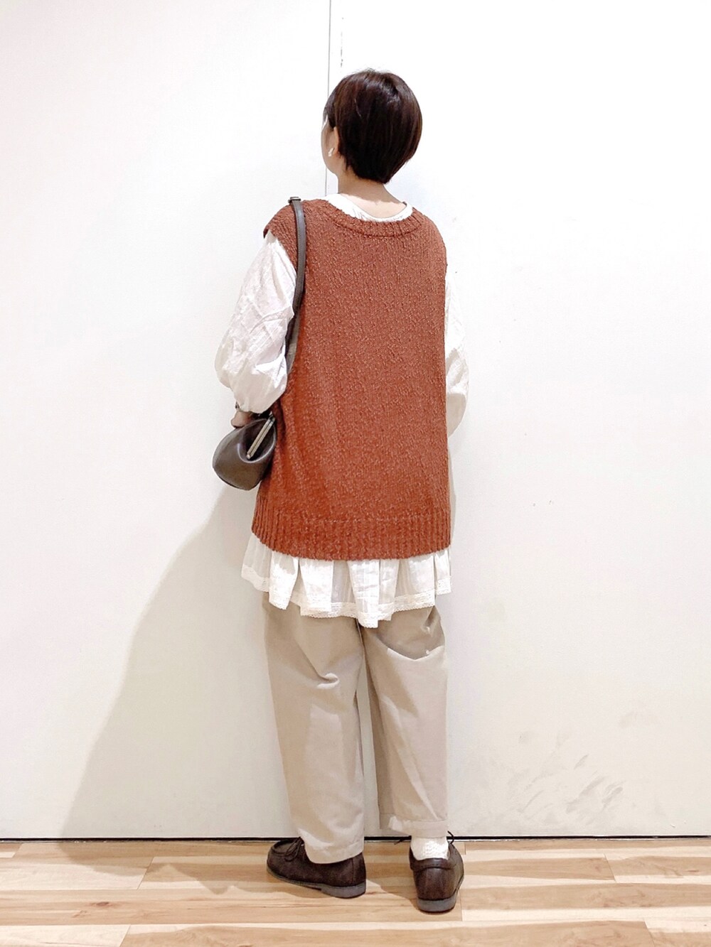 ブラウン系のハンドバッグ、ブラウン系のその他シューズ、ベージュ系のその他パンツを着用したレディースの秋コーディネートの5枚目の写真