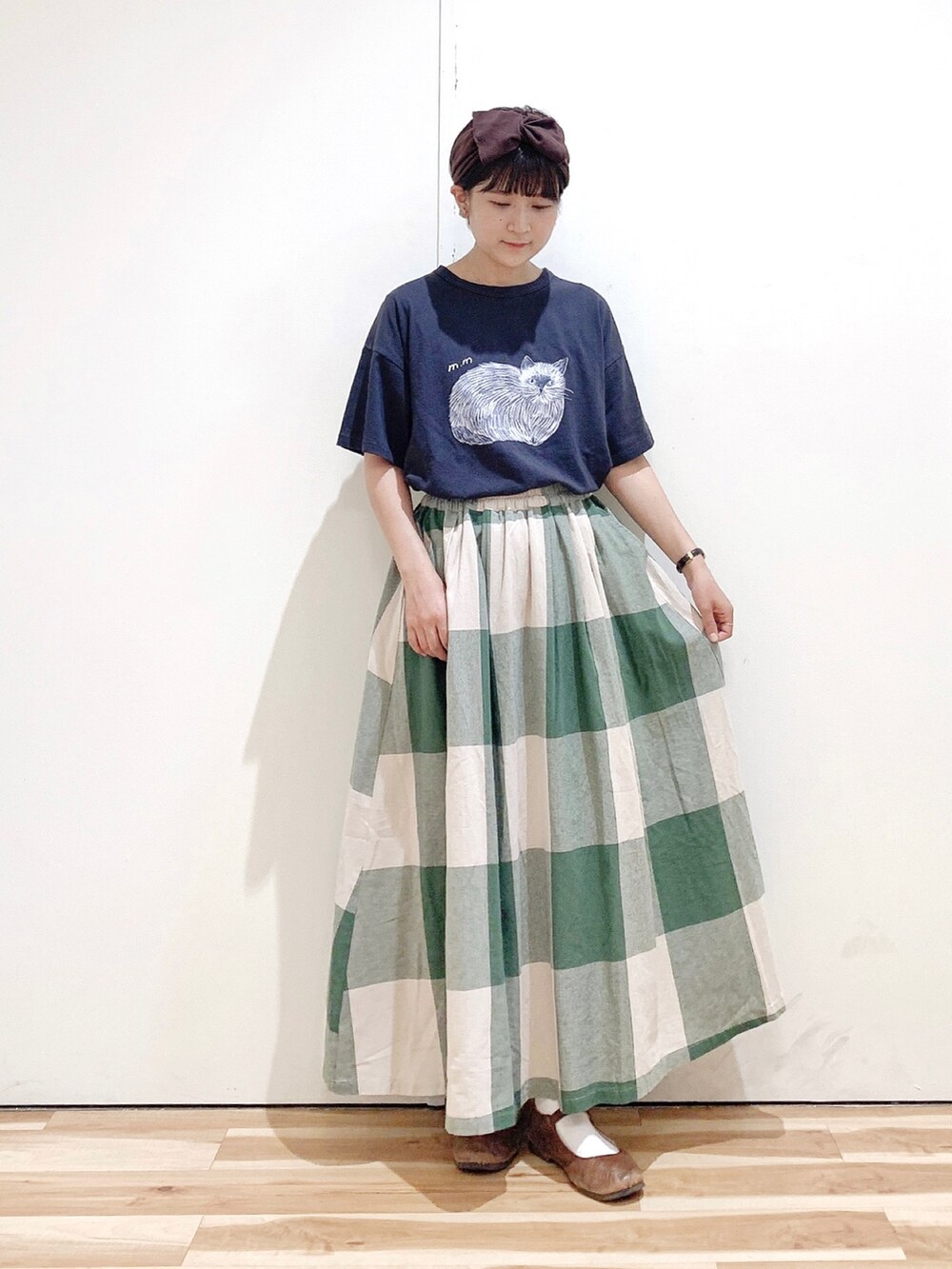 グリーン系のスカート、グレー系のTシャツ/カットソー、ブラウン系のバレエシューズを着用したレディースの秋コーディネートの3枚目の写真