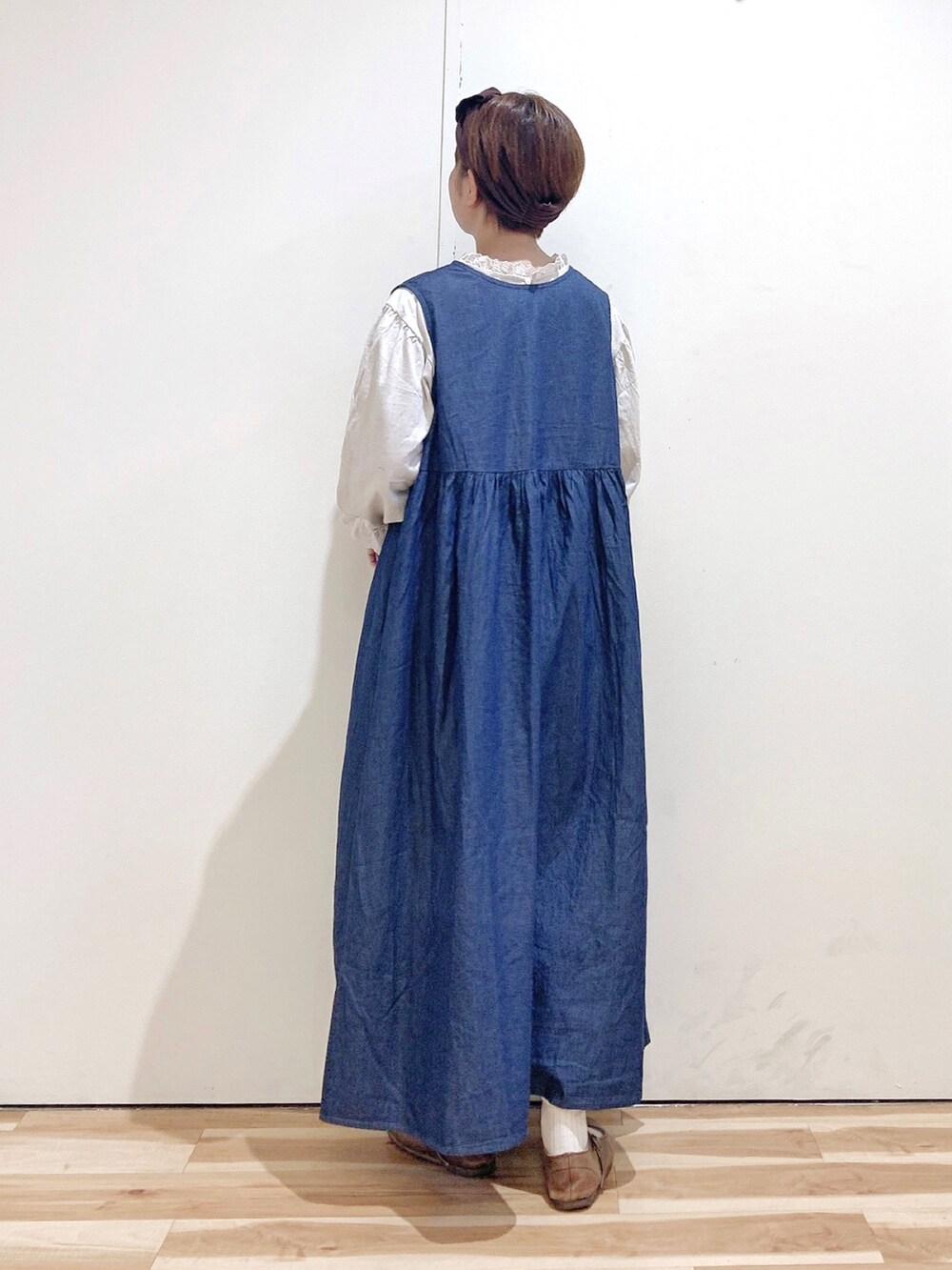 ブラウン系のバレエシューズ、ブルー系のワンピース、ホワイト系のTシャツ/カットソーを着用したレディースの秋コーディネートの5枚目の写真