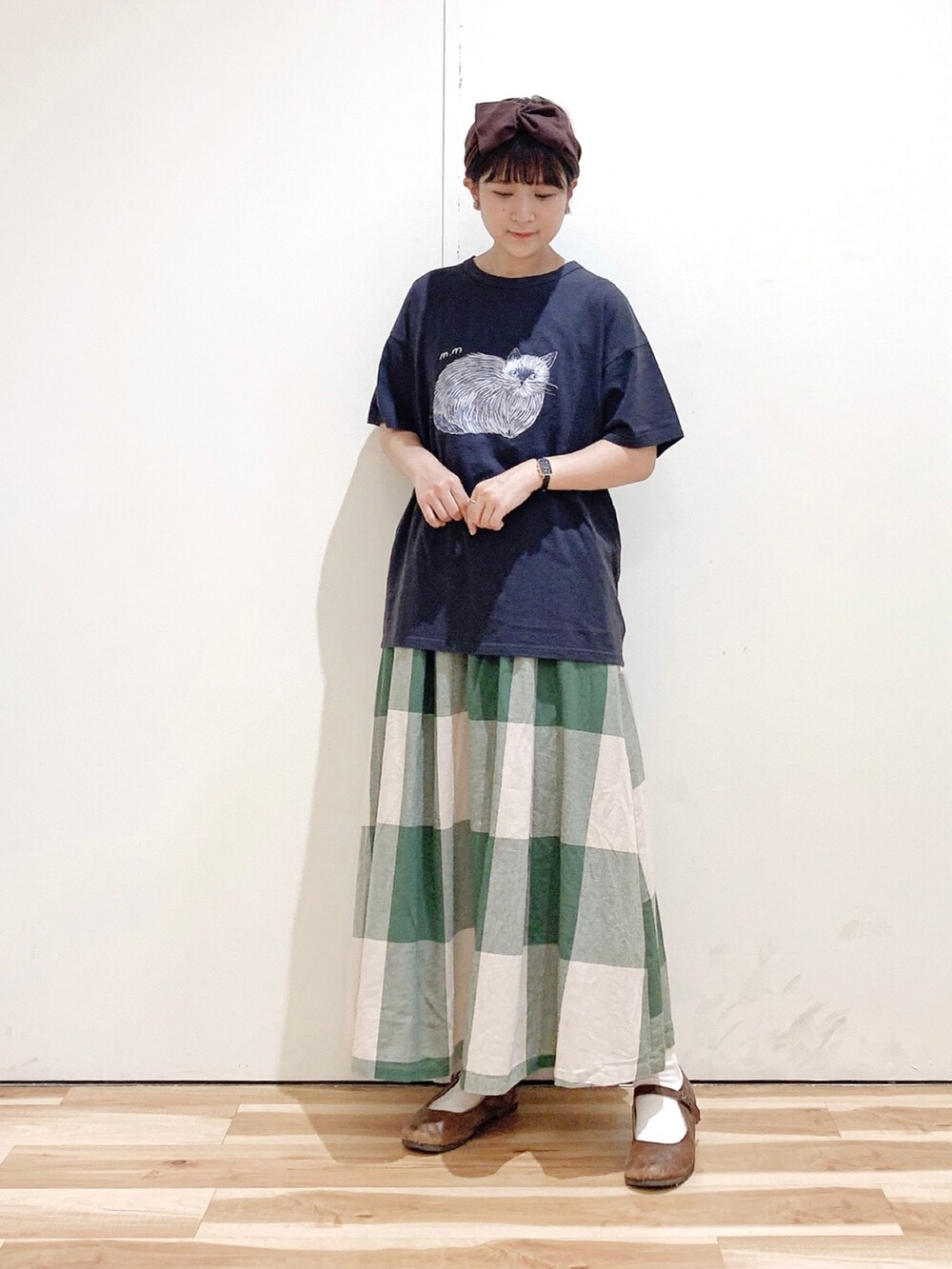 グリーン系のスカート、グレー系のTシャツ/カットソー、ブラウン系のバレエシューズを着用したレディースの秋コーディネートの4枚目の写真