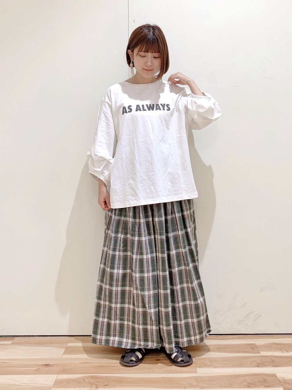 ブラウン系のサンダル、ホワイト系のTシャツ/カットソー、グリーン系のスカートを着用したレディースの春コーディネートの3枚目の写真