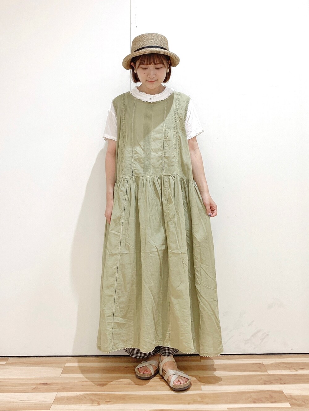 グリーン系のワンピース、ホワイト系のシャツ/ブラウス、ベージュ系のサンダルを着用したレディースの夏コーディネートの3枚目の写真
