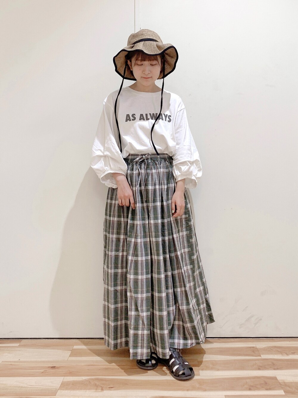 ブラウン系のサンダル、ホワイト系のTシャツ/カットソー、グリーン系のスカートを着用したレディースの春コーディネートの4枚目の写真