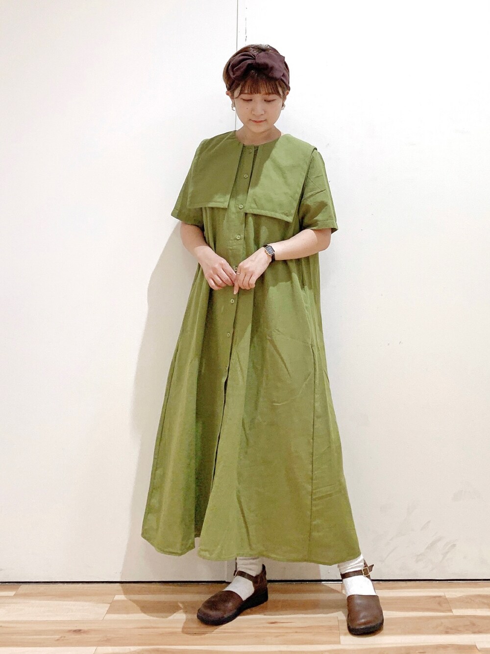 グリーン系のワンピース、ブラウン系のシューズ、ブラウン系のヘアバンドを着用したレディースの夏コーディネートの2枚目の写真