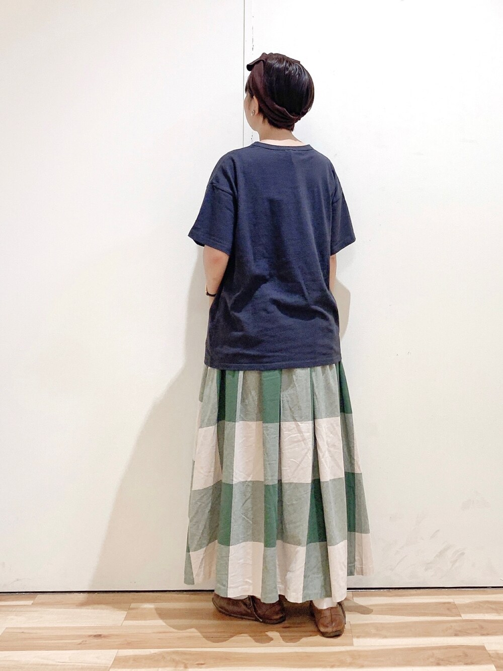 グリーン系のスカート、グレー系のTシャツ/カットソー、ブラウン系のバレエシューズを着用したレディースの秋コーディネートの5枚目の写真