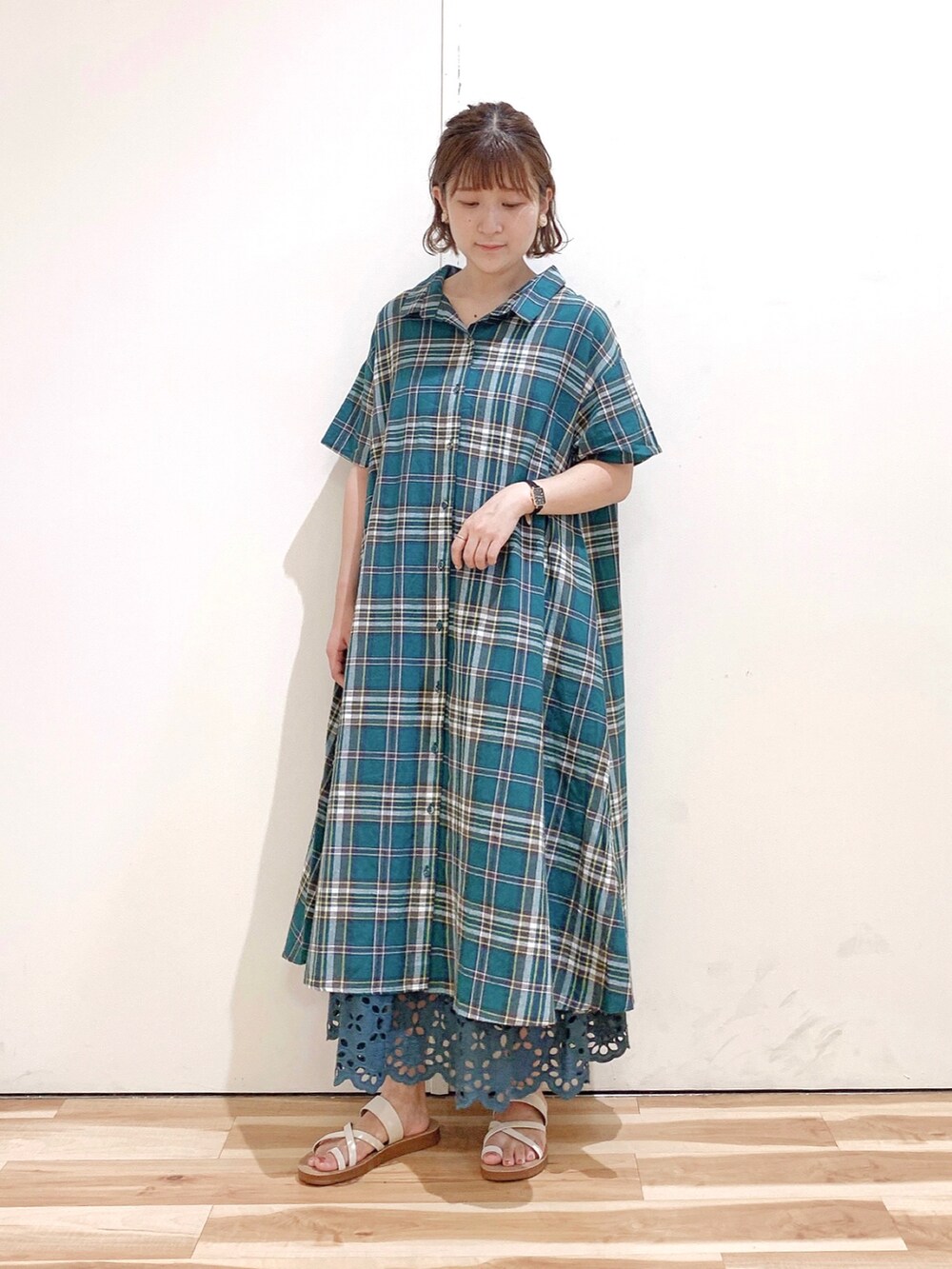 グリーン系のシャツワンピース、グリーン系のスカート、ホワイト系のサンダルを着用したレディースの夏コーディネートの3枚目の写真