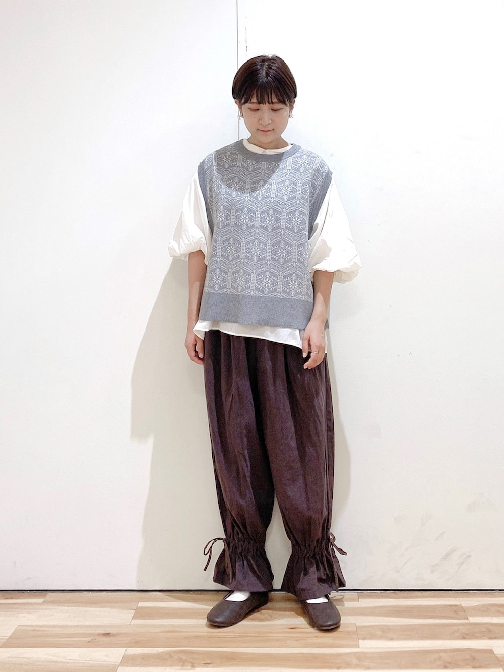 ブラウン系のその他パンツ、グレー系のベスト、ホワイト系のシャツ/ブラウスを着用したレディースの秋コーディネートの3枚目の写真
