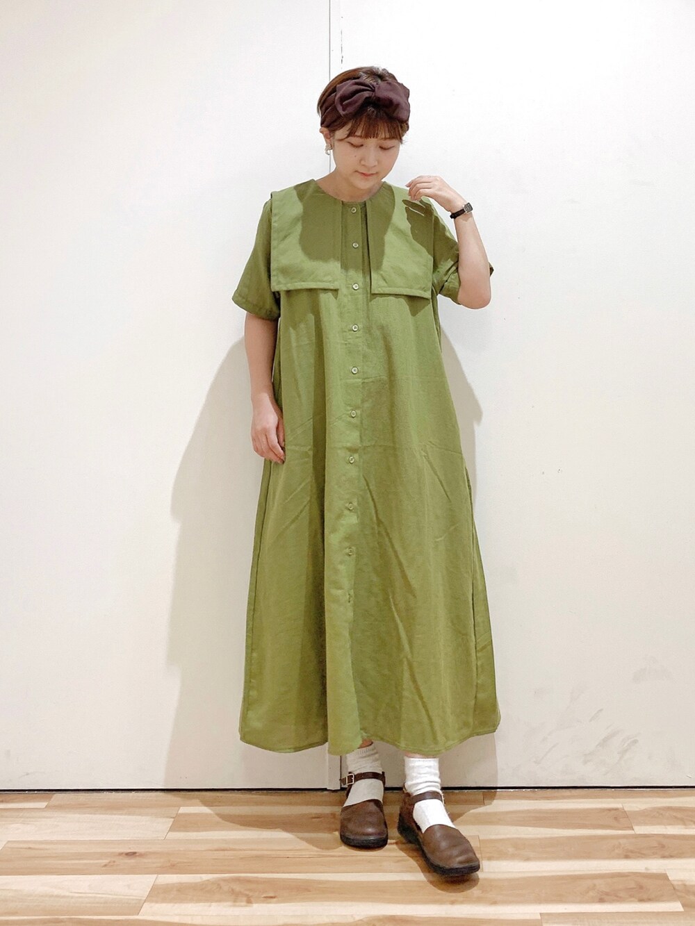 グリーン系のワンピース、ブラウン系のシューズ、ブラウン系のヘアバンドを着用したレディースの夏コーディネートの3枚目の写真