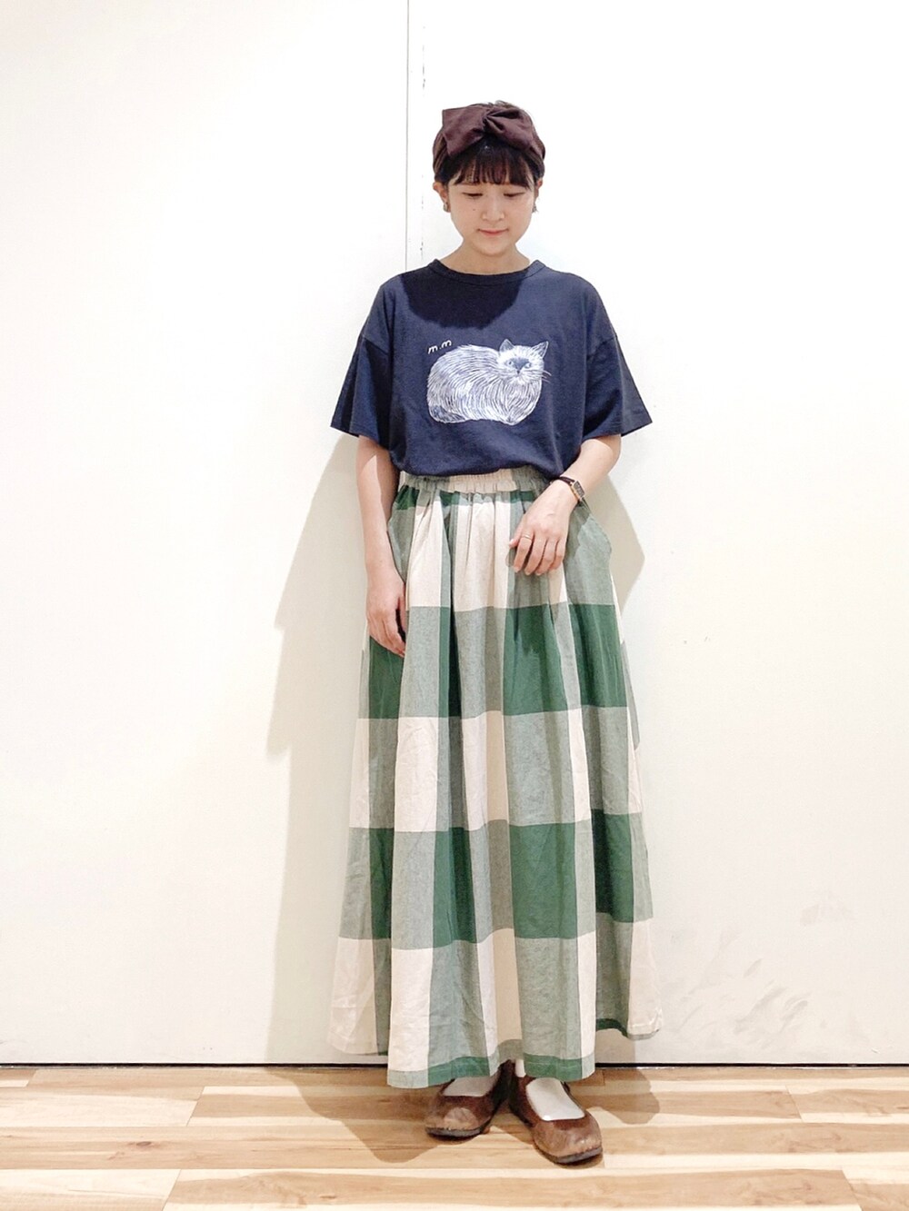 グリーン系のスカート、グレー系のTシャツ/カットソー、ブラウン系のバレエシューズを着用したレディースの秋コーディネートの2枚目の写真