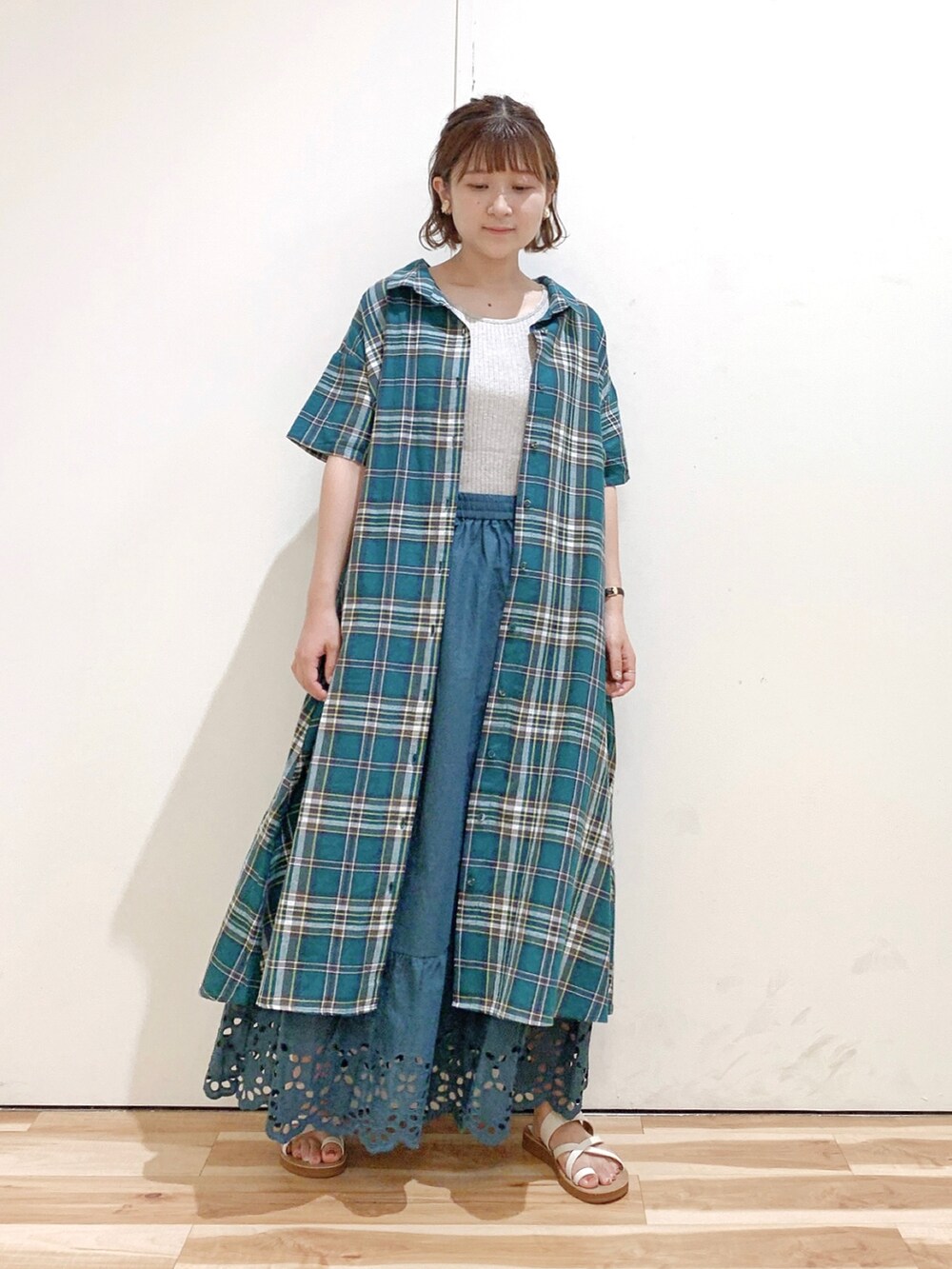 グリーン系のシャツワンピース、グリーン系のスカート、ホワイト系のサンダルを着用したレディースの夏コーディネートの5枚目の写真