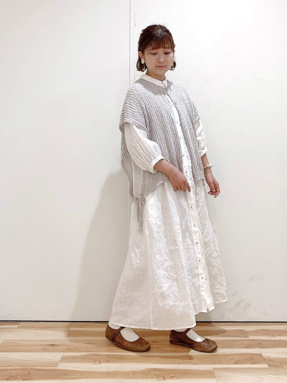 ブラウン系のバレエシューズ、ホワイト系のワンピース、ベージュ系のベストを着用したレディースの夏コーディネートの3枚目の写真