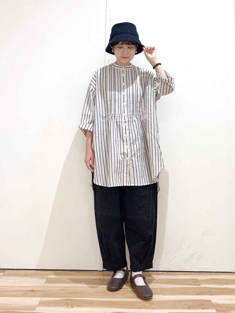 グレー系のシャツ/ブラウス、ブラック系のその他パンツ、ブラウン系のパンプスを着用したレディースの秋コーディネートの2枚目の写真