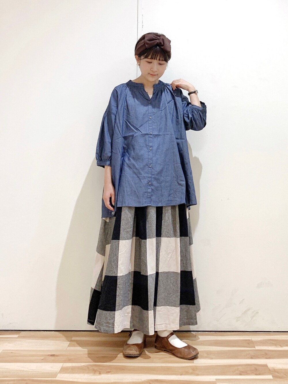 ブルー系のシャツ/ブラウス、ブラック系のスカート、ブラウン系のバレエシューズを着用したレディースの秋コーディネートの3枚目の写真