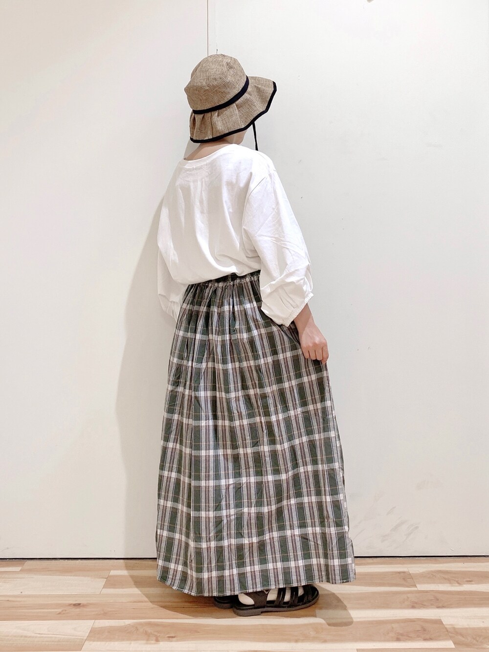 ブラウン系のサンダル、ホワイト系のTシャツ/カットソー、グリーン系のスカートを着用したレディースの春コーディネートの5枚目の写真