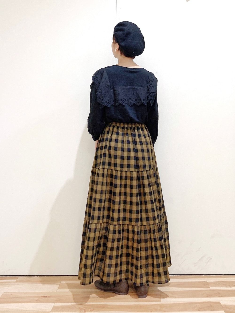 ブラック系のTシャツ/カットソー、ブラウン系のパンプス、イエロー系のスカートを着用したレディースの秋コーディネートの4枚目の写真