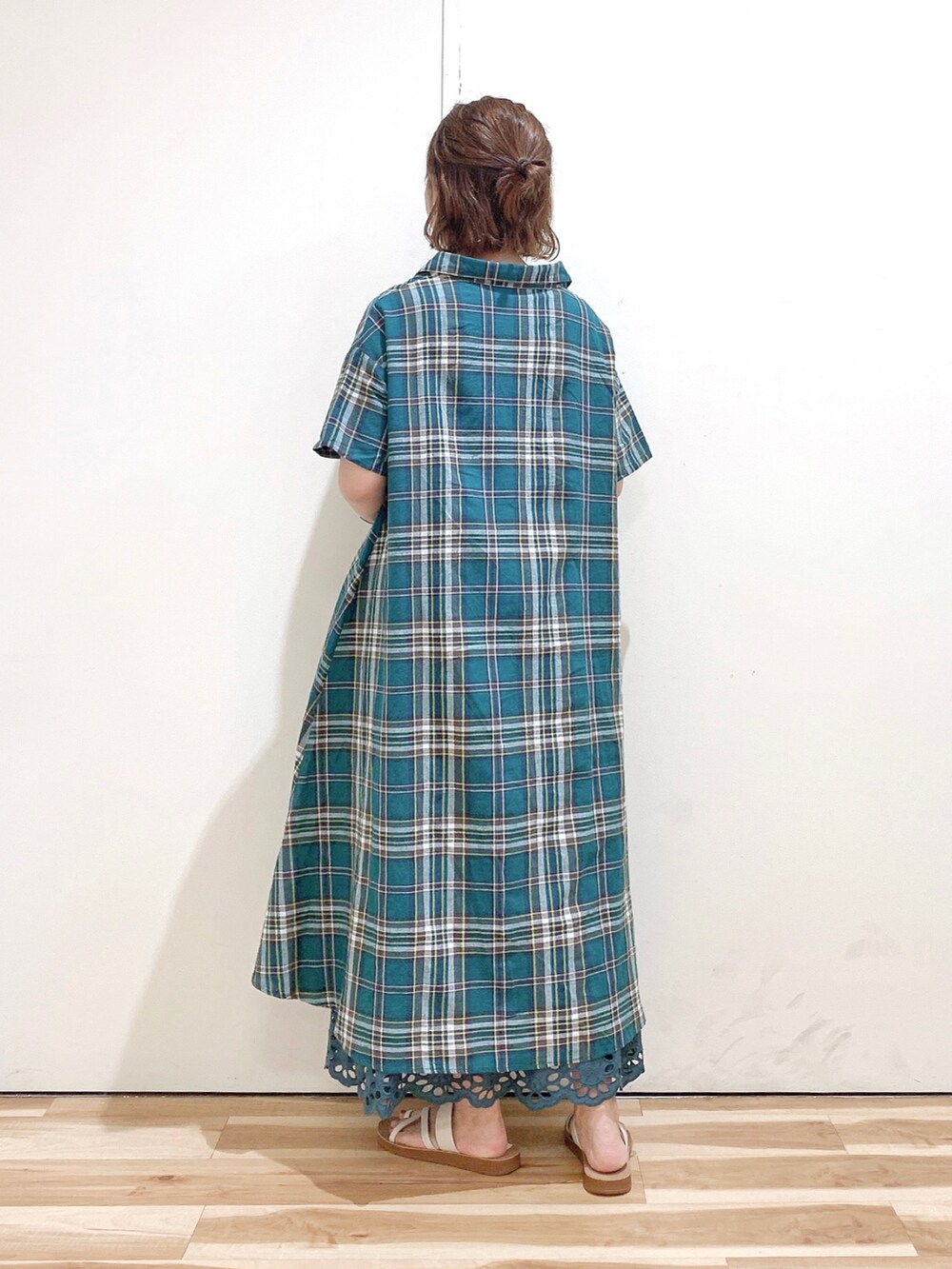 グリーン系のシャツワンピース、グリーン系のスカート、ホワイト系のサンダルを着用したレディースの夏コーディネートの4枚目の写真