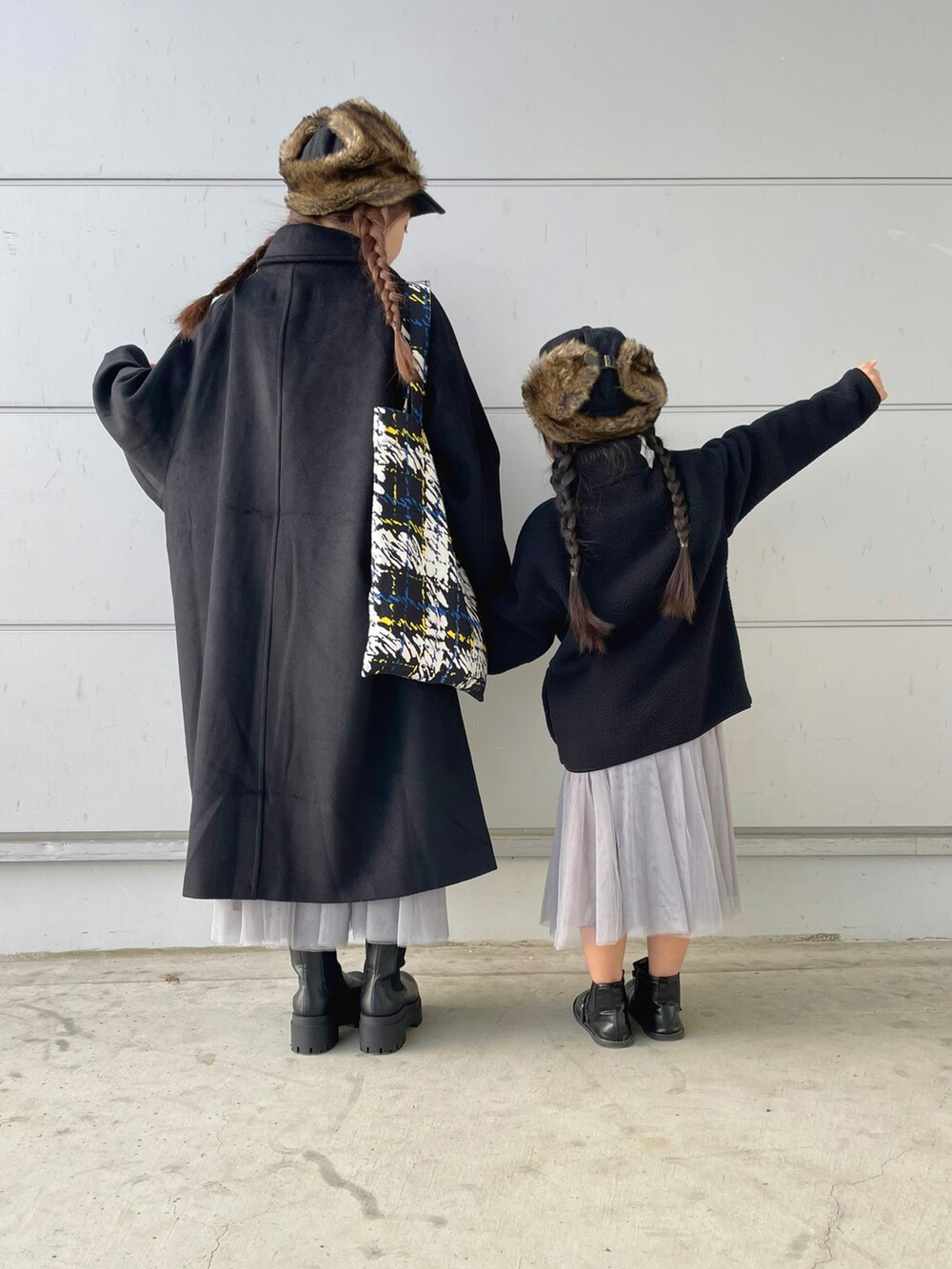 ブラック系のトートバッグ、ブラック系のステンカラーコート、グレー系のスカートを着用したレディースの秋コーディネートの2枚目の写真