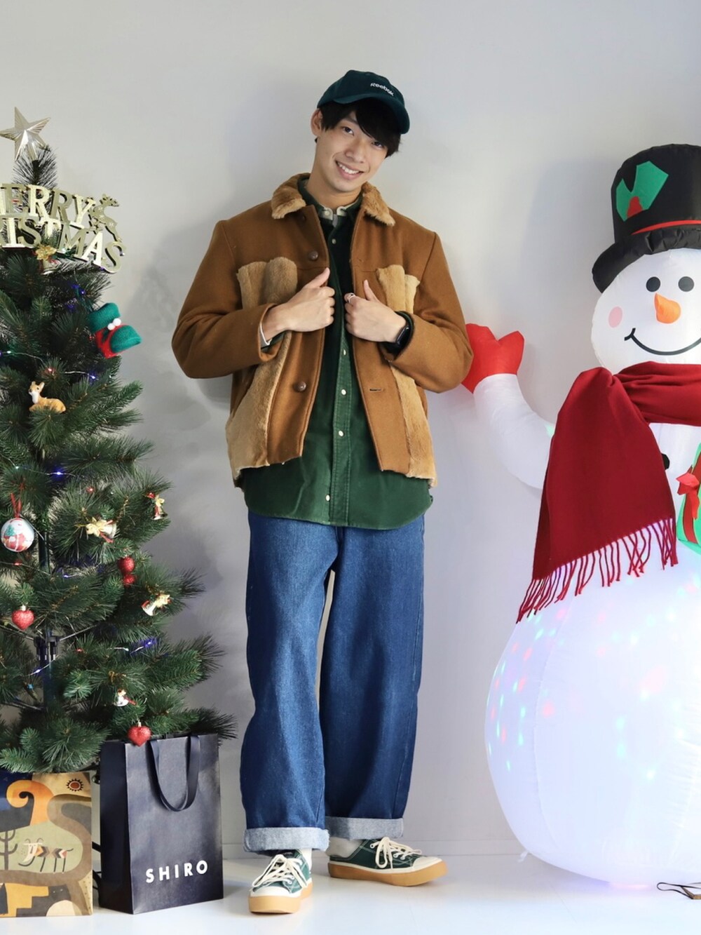 ブルー系のデニムパンツ、グリーン系のスニーカーを着用したメンズの冬コーディネートの2枚目の写真