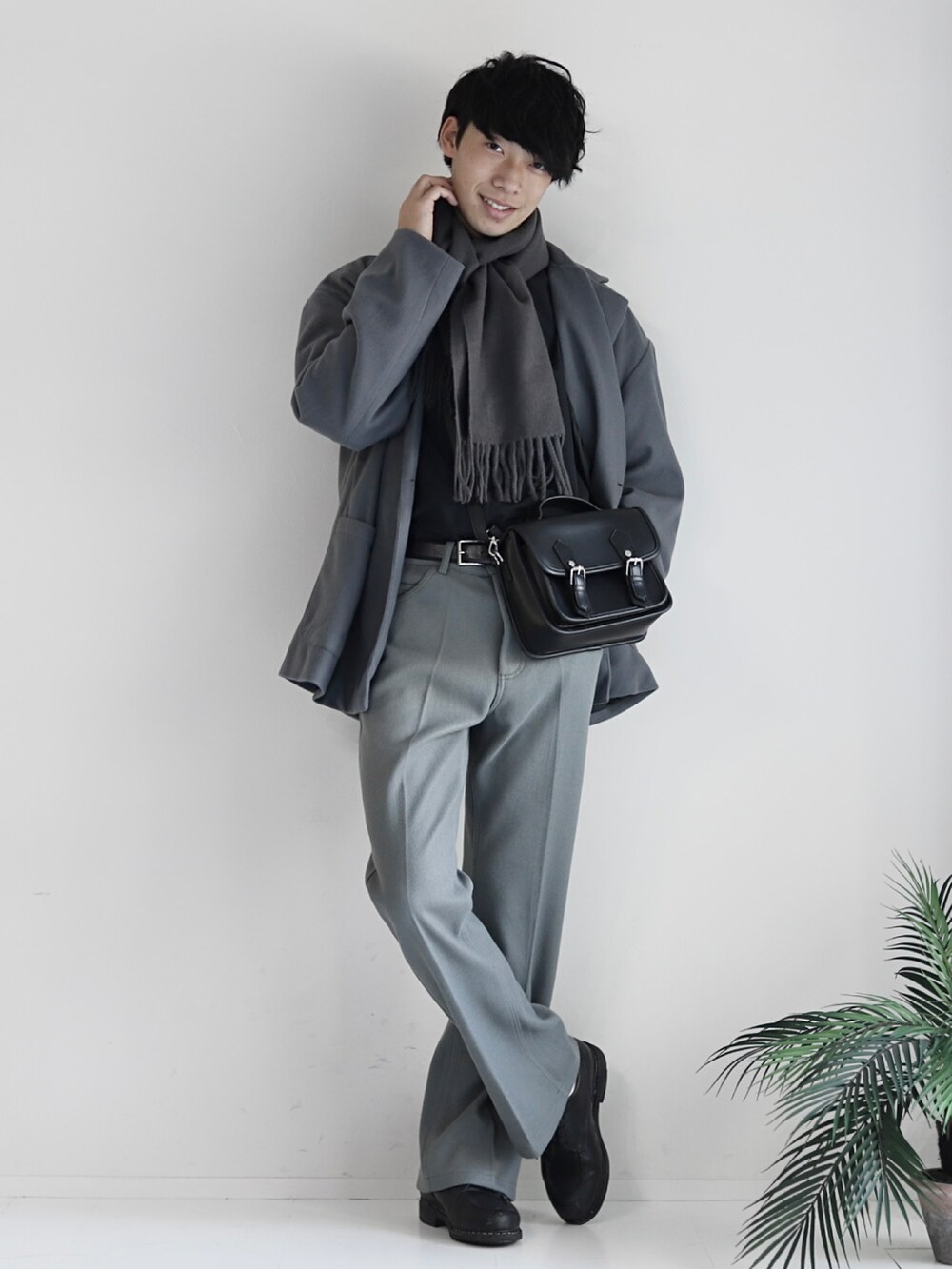 グレー系のスラックス、ブラック系のTシャツ/カットソー、ブラック系のショルダーバッグを着用したメンズの冬コーディネートの2枚目の写真