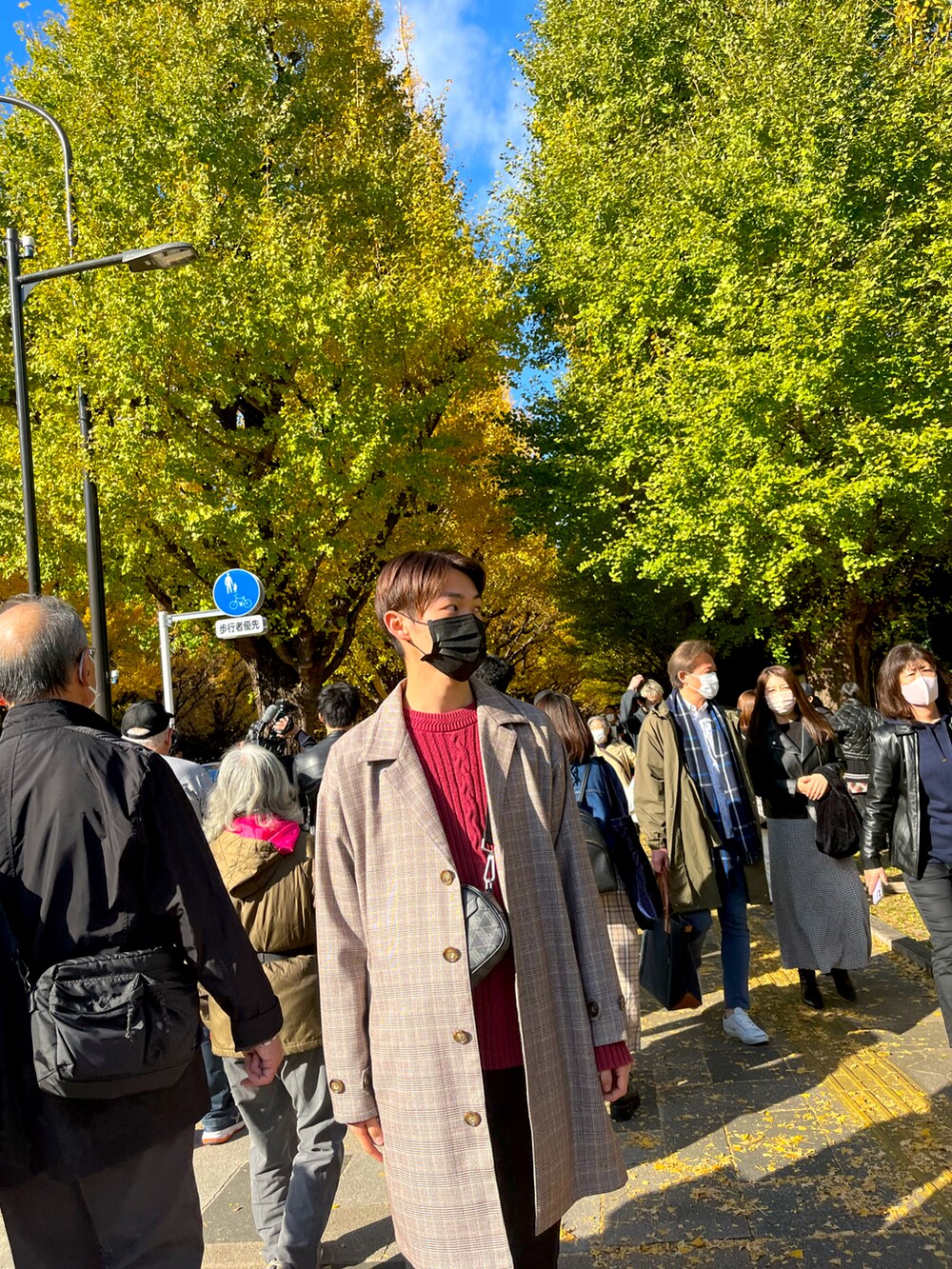 ベージュ系のトレンチコート、ブラック系のスラックス、レッド系のニット/セーターを着用したメンズの秋コーディネートの4枚目の写真