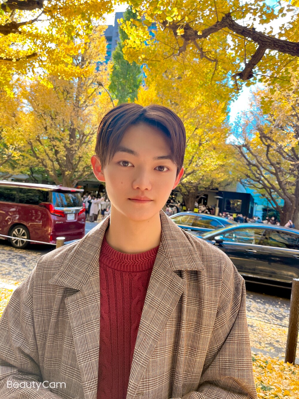 ベージュ系のトレンチコート、ブラック系のスラックス、レッド系のニット/セーターを着用したメンズの秋コーディネートの3枚目の写真