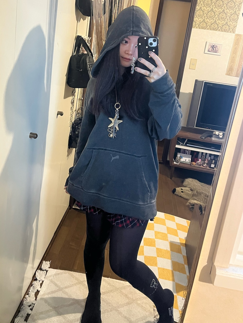 レッド系のパンツ、グレー系のパーカー、ブラック系のブーツを着用したレディースの秋コーディネートの2枚目の写真