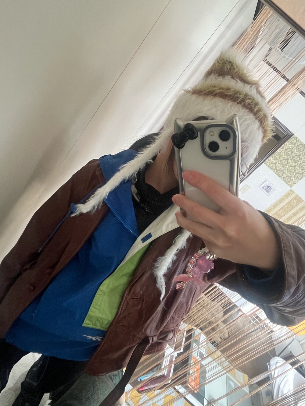 ブラウン系のジャケット/アウター、ブルー系のトップス、ブラック系のバッグを着用したレディースの冬コーディネートの2枚目の写真