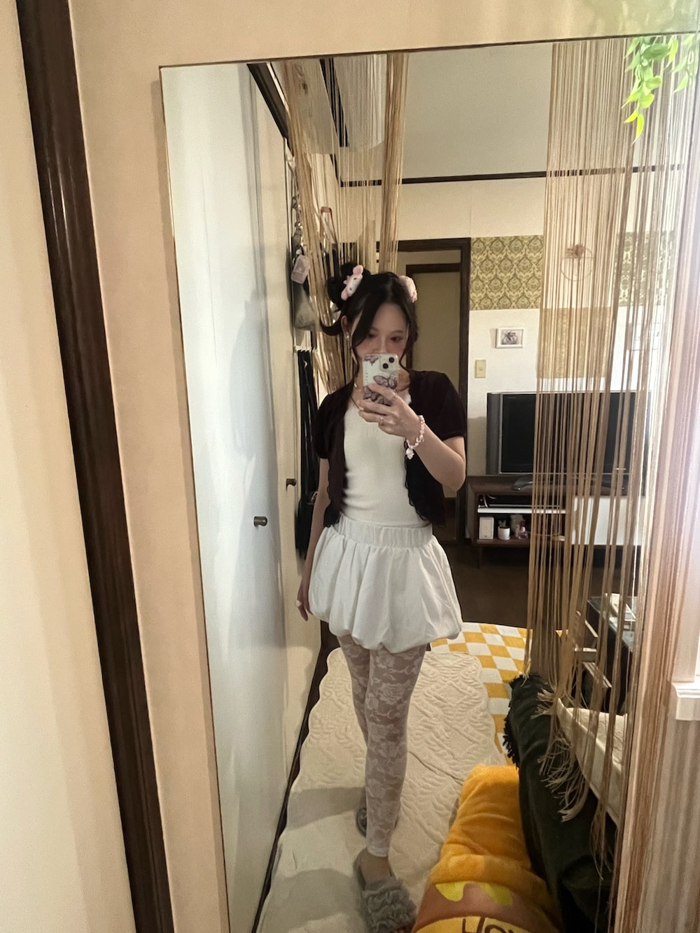 ホワイト系のスカート、ホワイト系のバッグ、ブラウン系のカーディガン/ボレロを着用したレディースの秋コーディネートの2枚目の写真