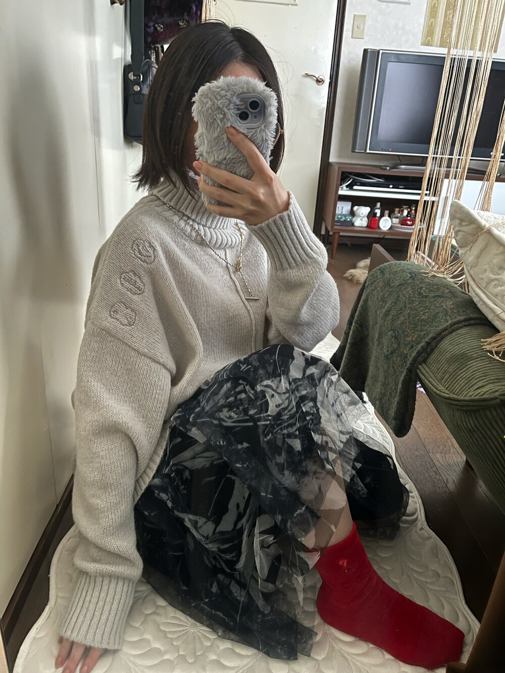 グレー系のニット/セーター、ブラック系のスカートを着用したレディースの秋コーディネートの2枚目の写真