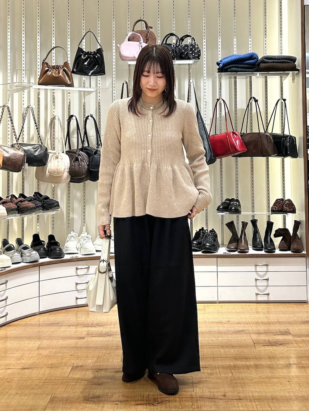 ブラック系のその他パンツ、ブラウン系のローファー、ベージュ系のカーディガン/ボレロを着用したレディースの秋コーディネートの3枚目の写真