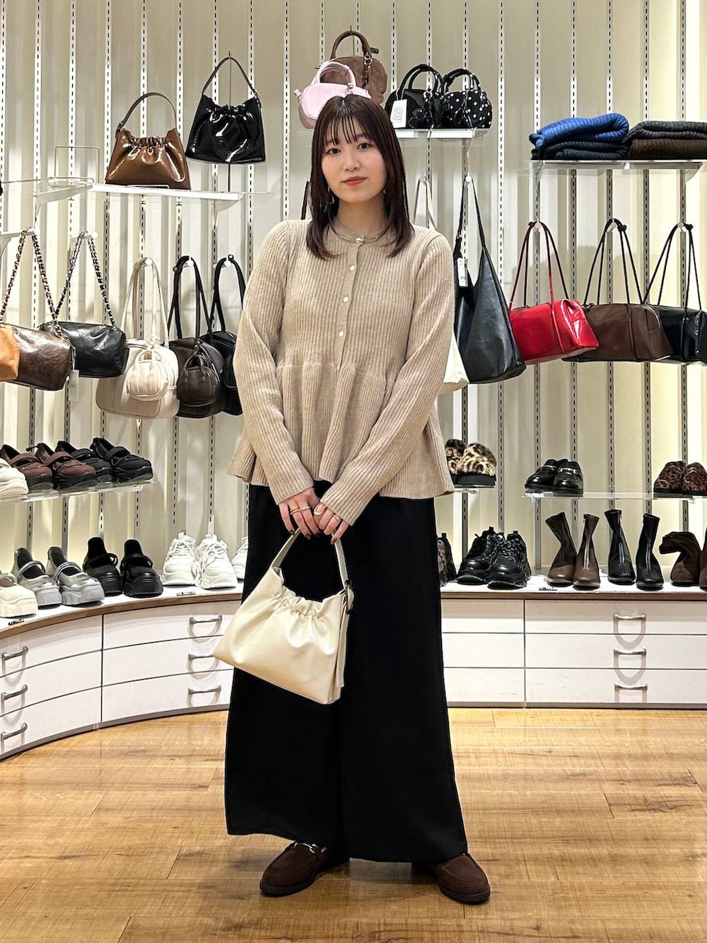 ブラック系のその他パンツ、ブラウン系のローファー、ベージュ系のカーディガン/ボレロを着用したレディースの秋コーディネートの2枚目の写真