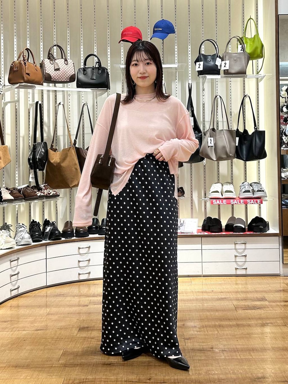 ブラック系のスカート、ブラウン系のショルダーバッグ、ブラック系のパンプスを着用したレディースの秋コーディネートの2枚目の写真