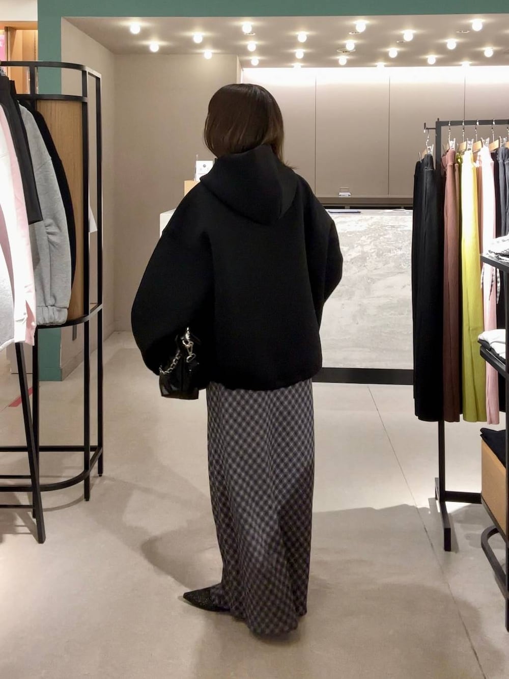 ブラック系のパンプス、ブラック系のショルダーバッグ、ブラック系のブルゾンを着用したレディースの冬コーディネートの2枚目の写真