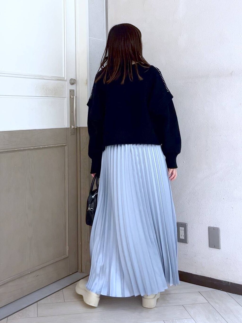 ブラック系のTシャツ/カットソー、ホワイト系のブーツ、ブラック系のボストンバッグを着用したレディースの冬コーディネートの4枚目の写真