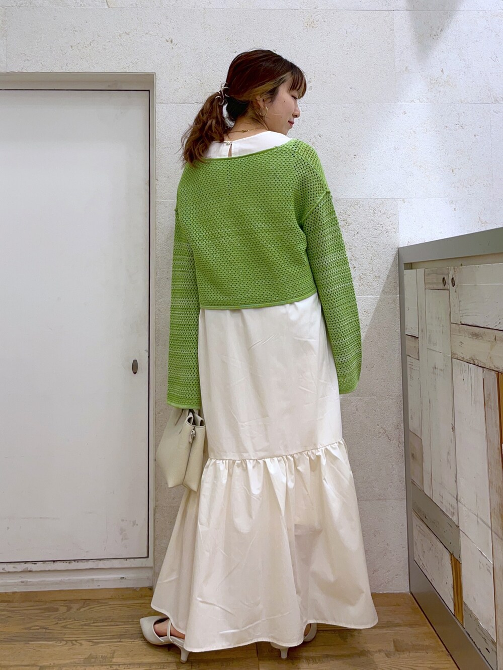 グリーン系のワンピース、ホワイト系のバッグ、ホワイト系のシューズを着用したレディースの春コーディネートの3枚目の写真